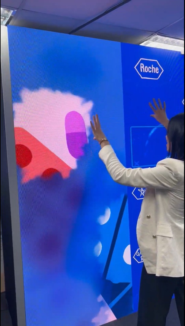 Participante interagindo com instalação da Roche